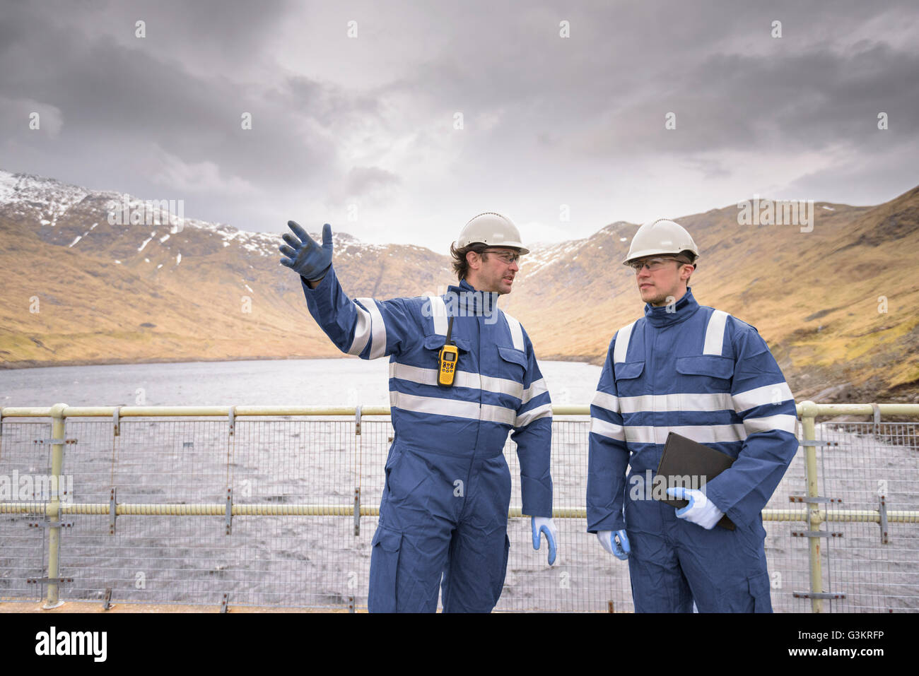 Arbeitnehmer auf Damm am Wasserkraftwerk mit Wasser Stockfoto