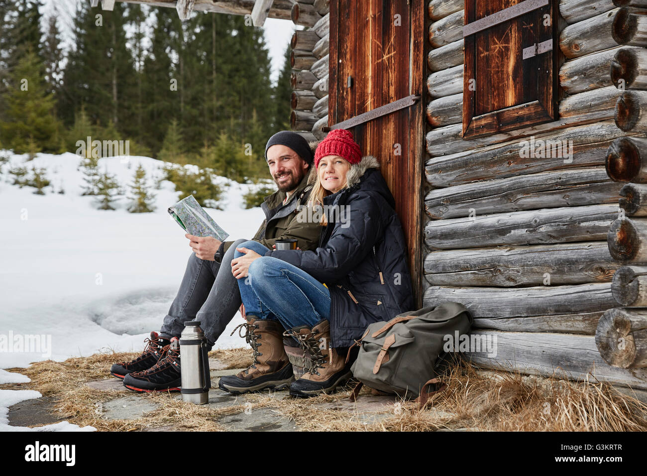 Porträt des Paares lesen Karte draußen Blockhaus im Winter, Elmau, Bayern, Deutschland Stockfoto