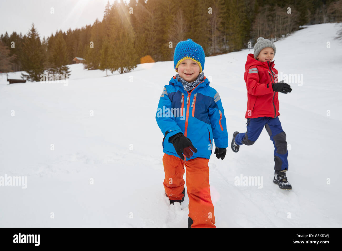 Junge und Bruder laufen im Schnee bedeckt Landschaft, Elmau, Bayern, Deutschland Stockfoto