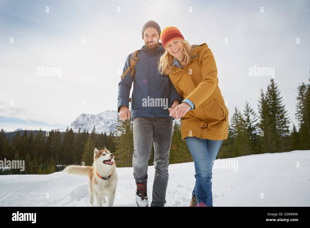 Porträt des Paares zu Fuß husky im Schnee bedeckt Landschaft, Elmau, Bayern, Deutschland Stockfoto