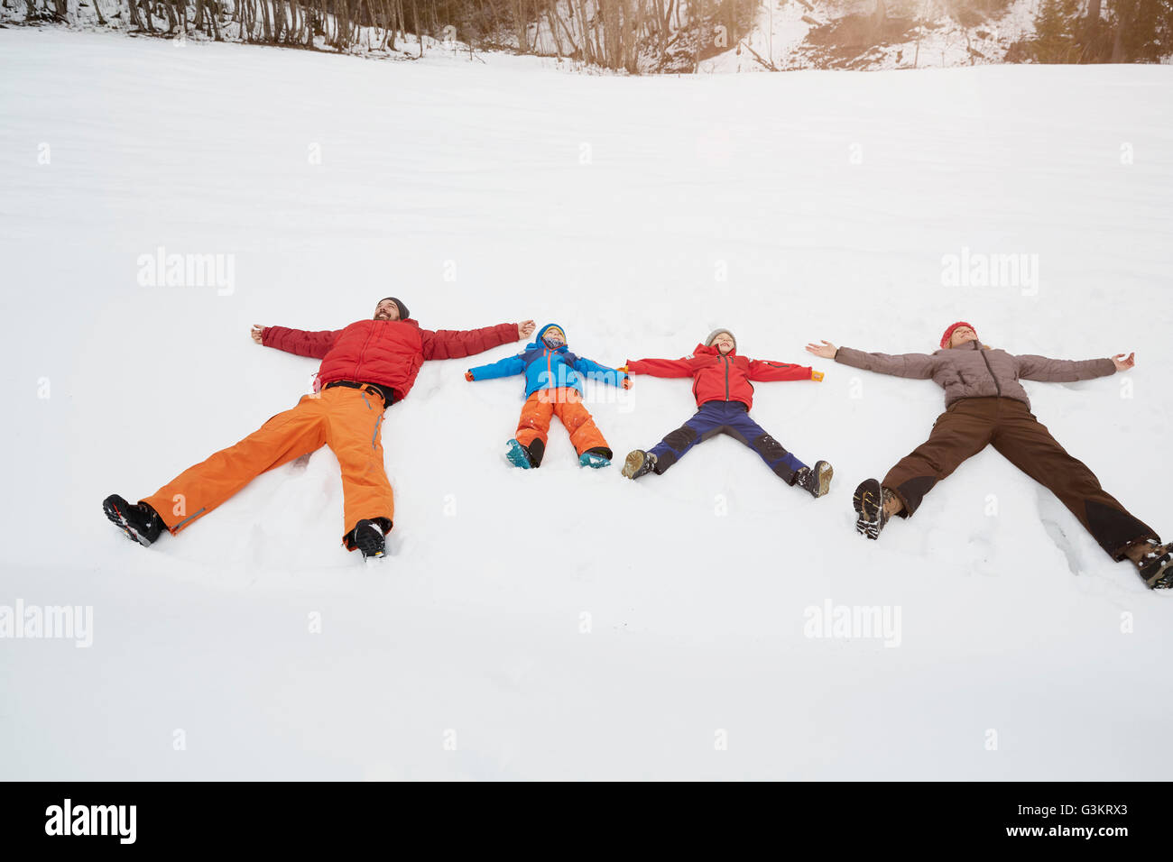 Eltern und Söhne liegen im Schnee bedeckt Landschaft, Elmau, Bayern, Deutschland Stockfoto