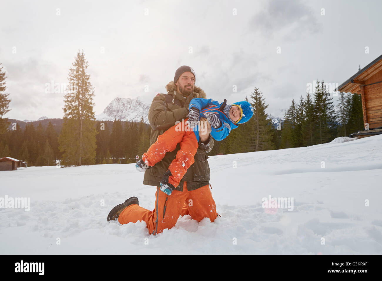 Vater hob Sohn im Schnee, Elmau, Bayern, Deutschland Stockfoto