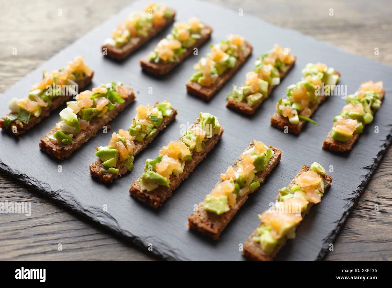 Guacamole, Räucherlachs und Roggenbrot Kanapees Stockfoto