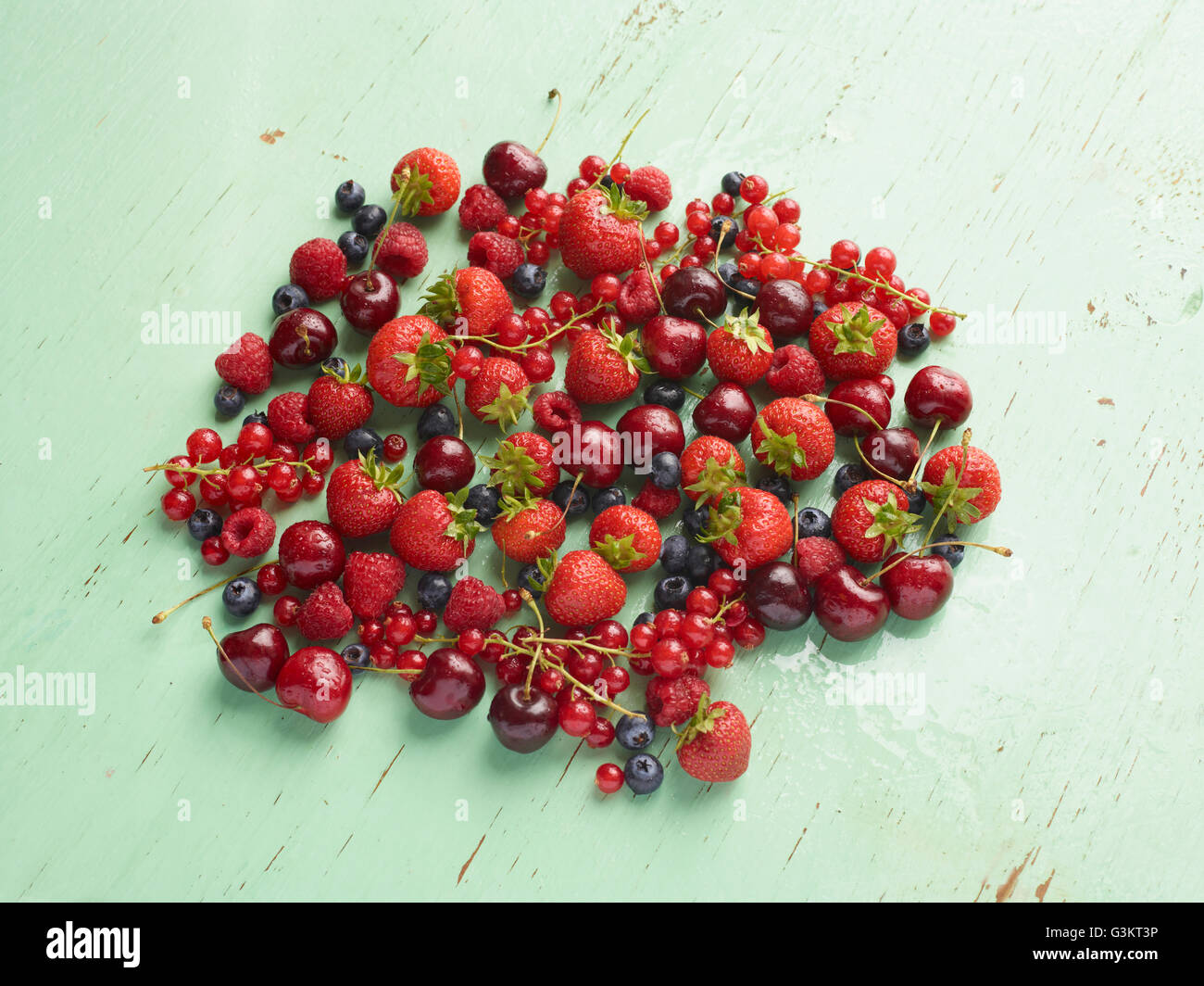 Draufsicht der roten Sommerfrüchten auf grünem Hintergrund Stockfoto