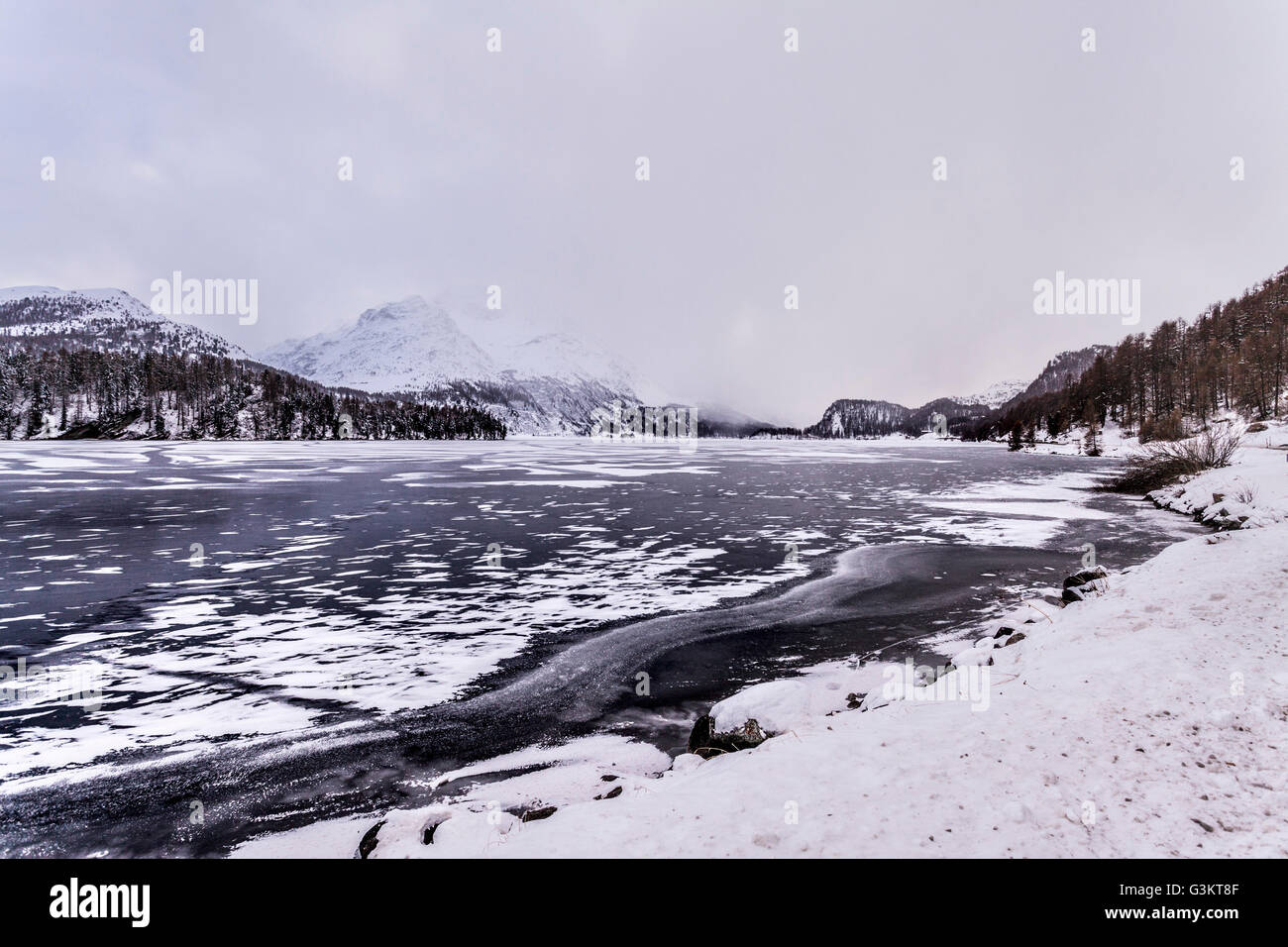 Zugefrorenen See und Schnee bedeckt Berge, Engadin, Schweiz Stockfoto