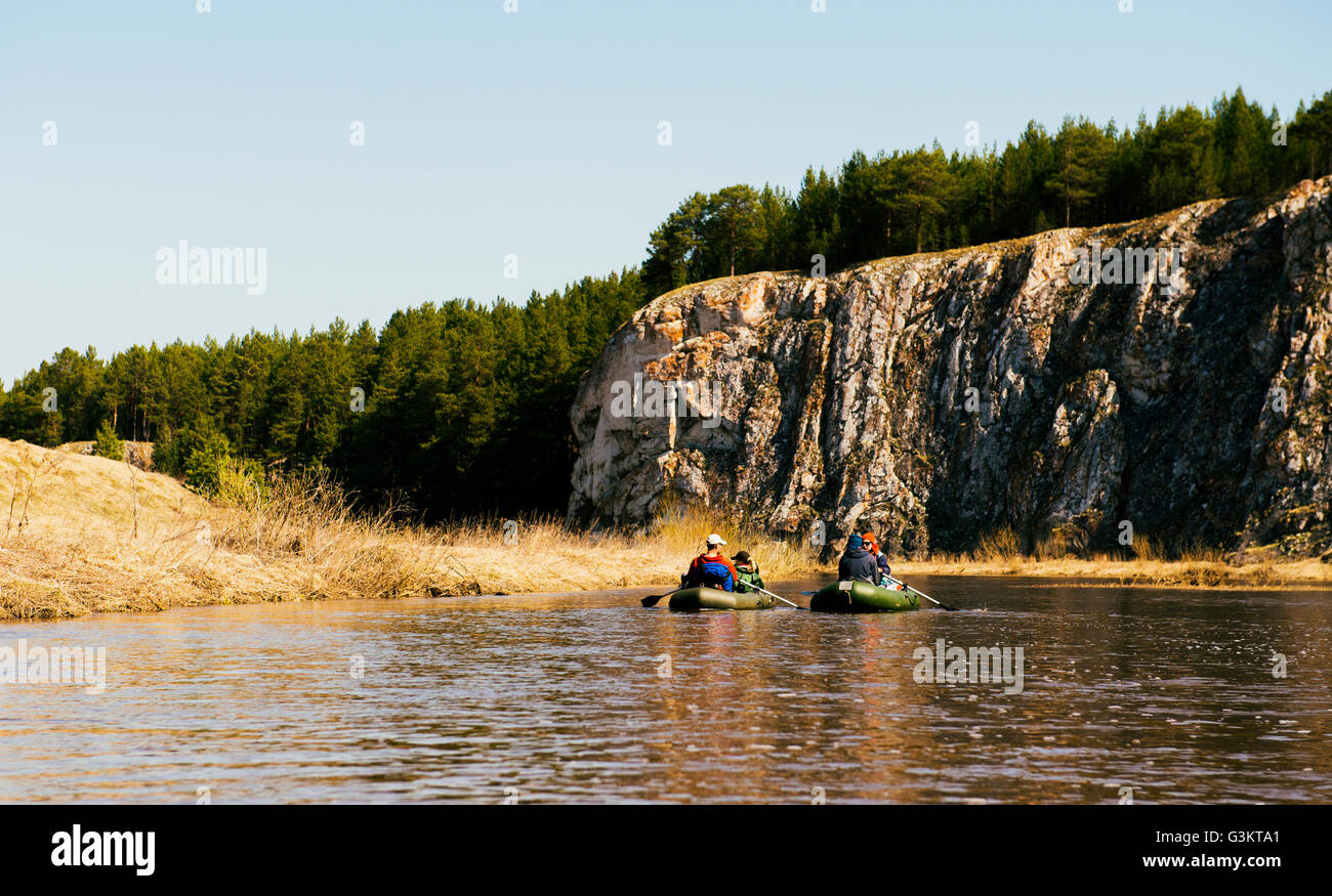 Gruppe von Freunden am Fluss in Schlauchbooten durch die Felswand Stockfoto