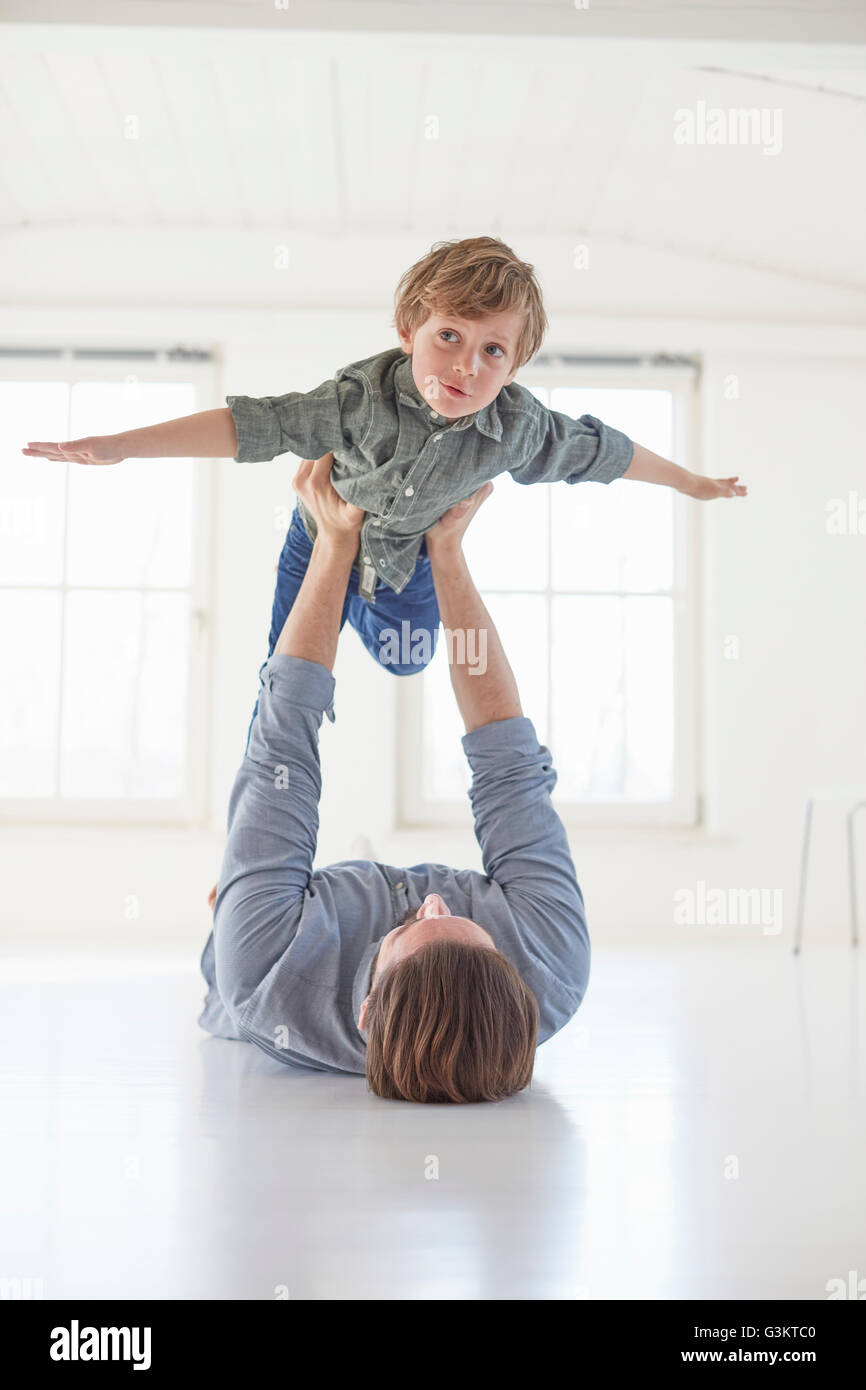 Vater auf Sohn hält Boden liegend Stockfoto