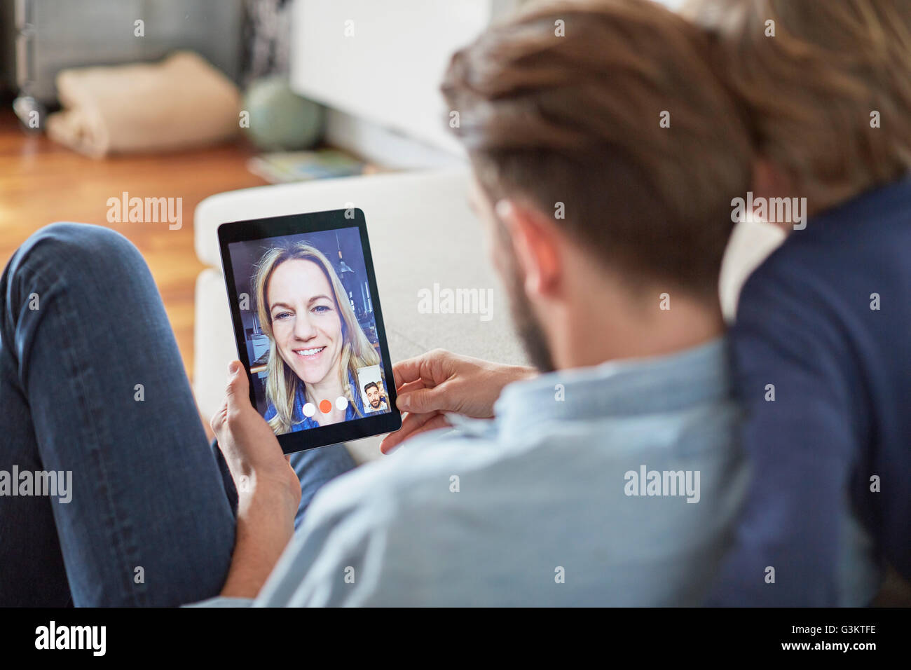 Mann und Sohn sitzen auf Boden Gespräch mit Mutter auf digitale Tablet video aufrufen Stockfoto