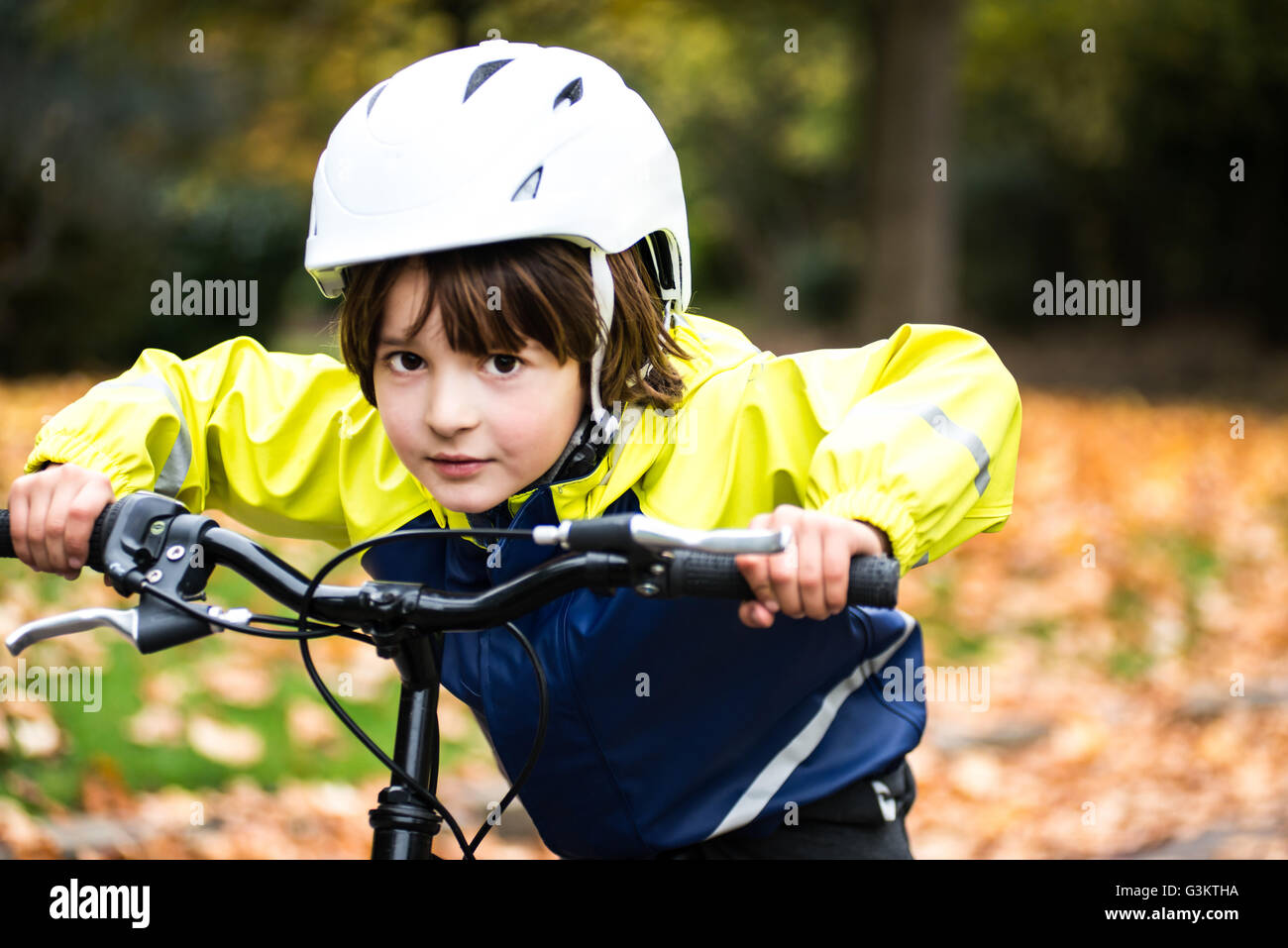 Jungen Fahrrad Helm auf dem Fahrrad, Blick in die Kamera Stockfoto