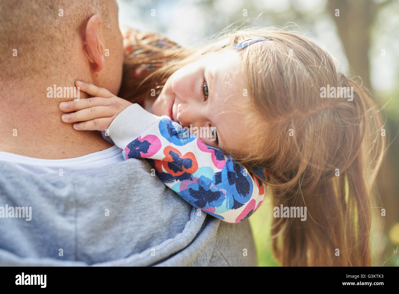 Über Schulter Blick des Vaters tragen lächelnd Tochter Stockfoto