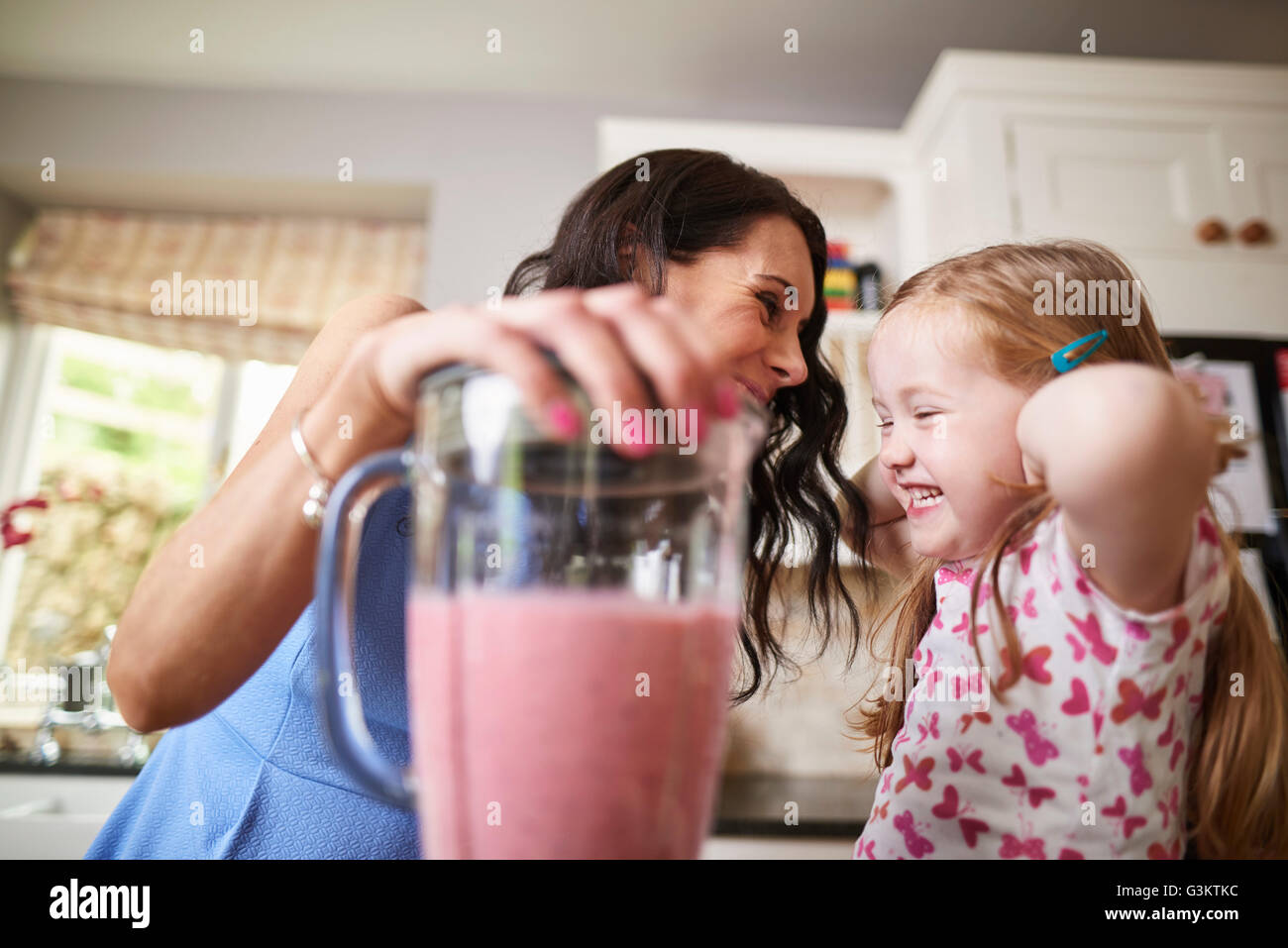 Mutter und Tochter machen Smoothies in lauten Mixer Stockfoto