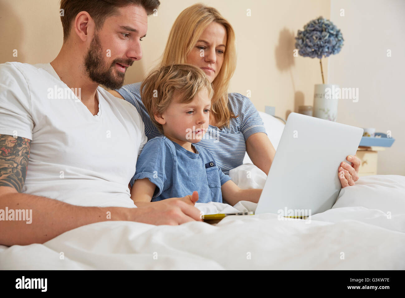 Mutter und Vater im Bett mit Sohn mit digital-Tablette Stockfoto