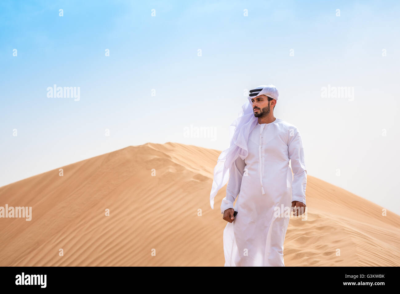 Nahen Ostens Mann Tracht auf einsamen Düne, Dubai, Vereinigte Arabische Emirate Stockfoto