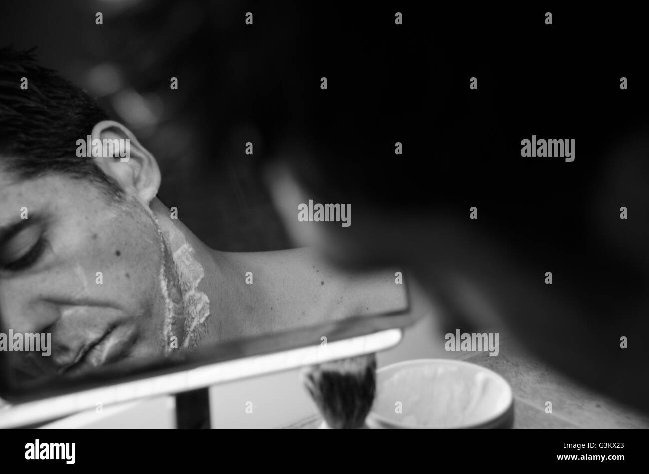 Mann im Spiegel mit Bürste, Creme und Rasierer Nassrasur Stockfoto