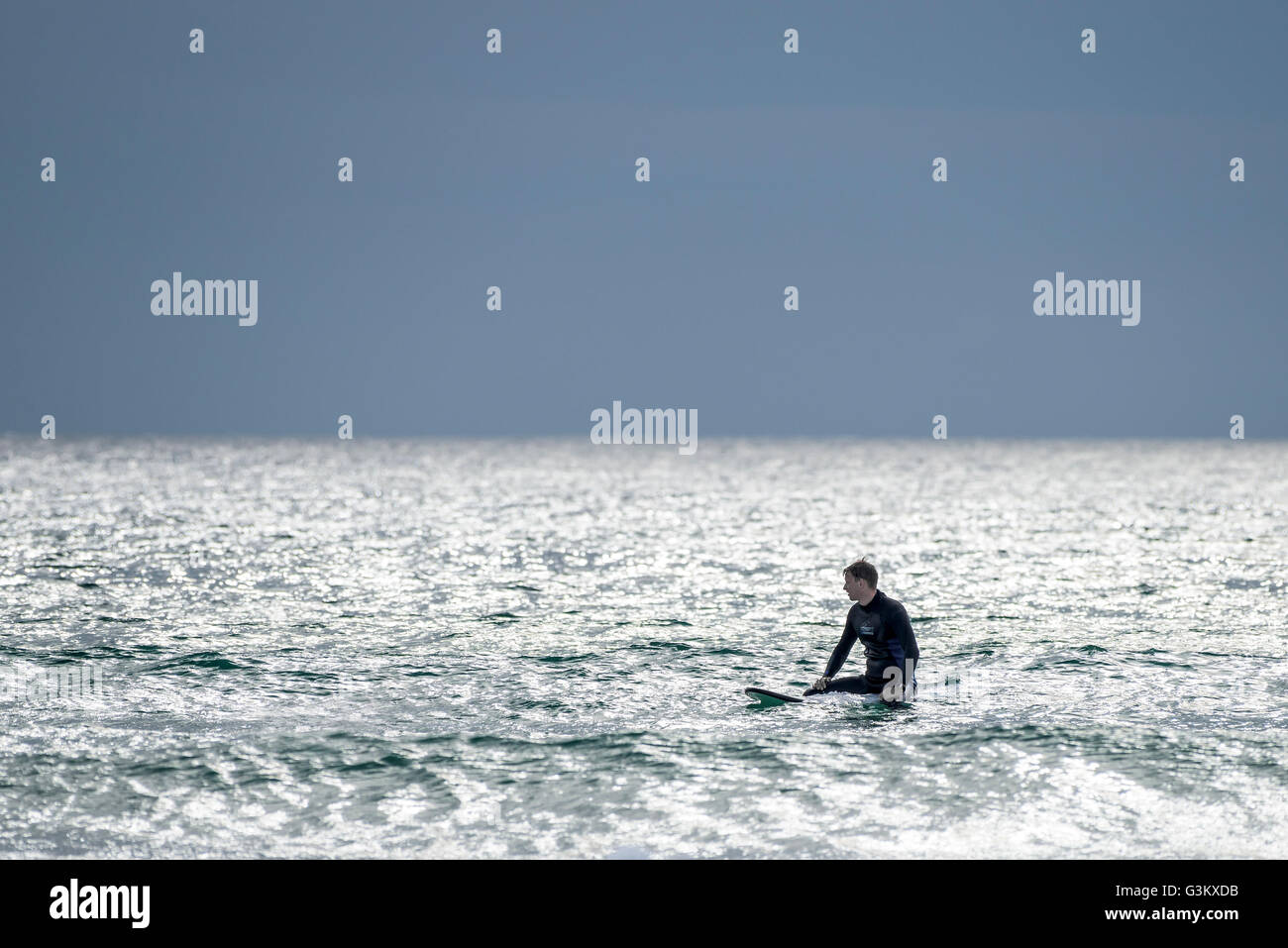 Ein Surfer für eine Welle an Fistral in Newquay, Cornwall wartet. Stockfoto