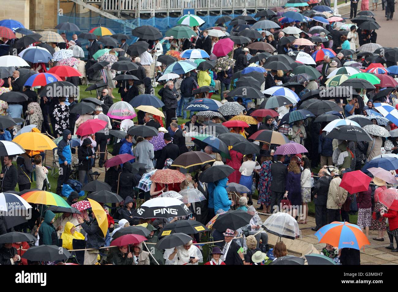 Mitglieder der Öffentlichkeit trotzen Regen, während sie darauf, für die Ankunft der Königin Elizabeth II. vor der jährlichen Reihenfolge des Hosenbandordens Service an Str. Georges Kapelle, Windsor Castle warten. Stockfoto