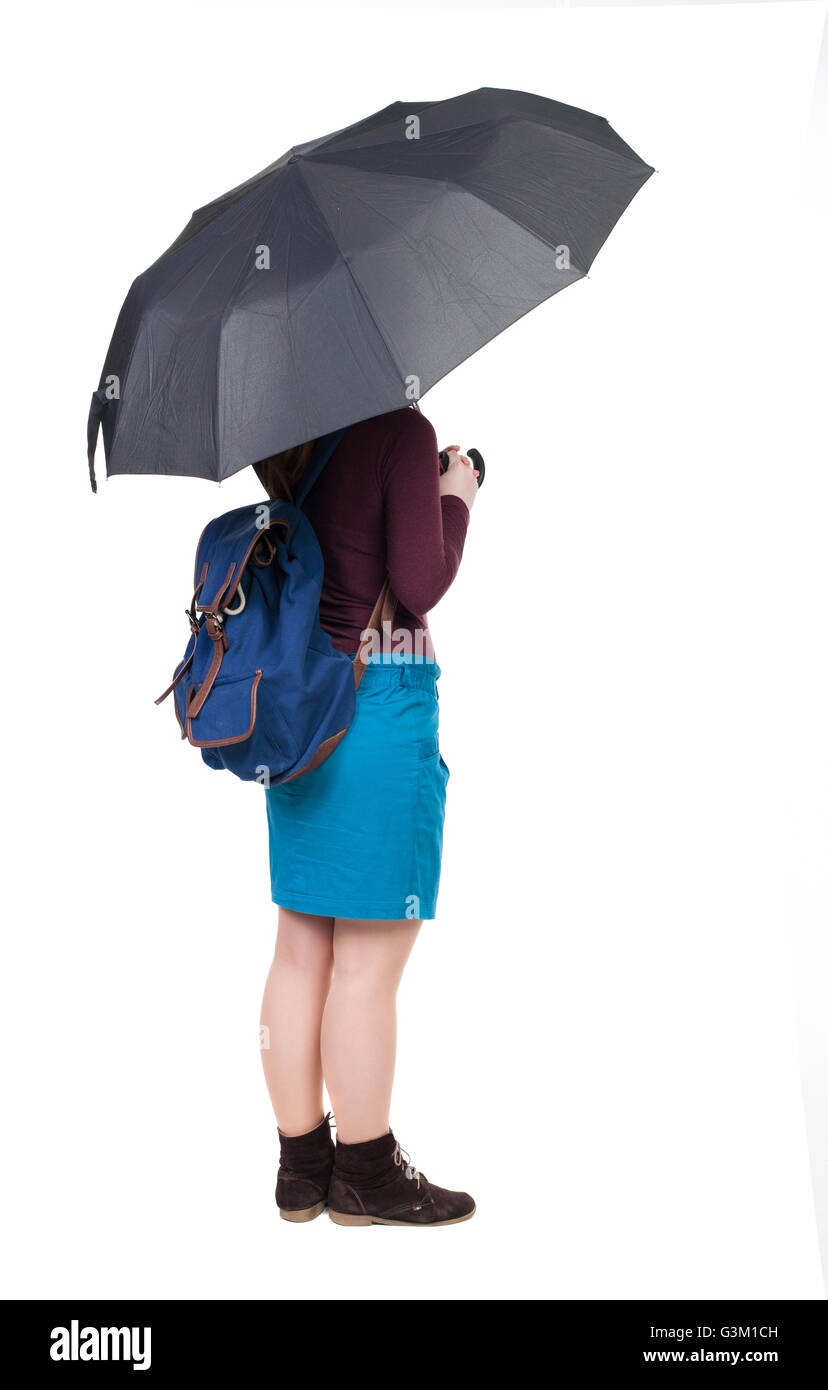 junge Frau mit einem Rucksack unter einem Regenschirm. Hintere Ansicht Menschen Sammlung. Rückseite Blick auf Person. Isoliert auf weißem Hintergrund. Touristische Attraktionen untersucht den Regen. Stockfoto