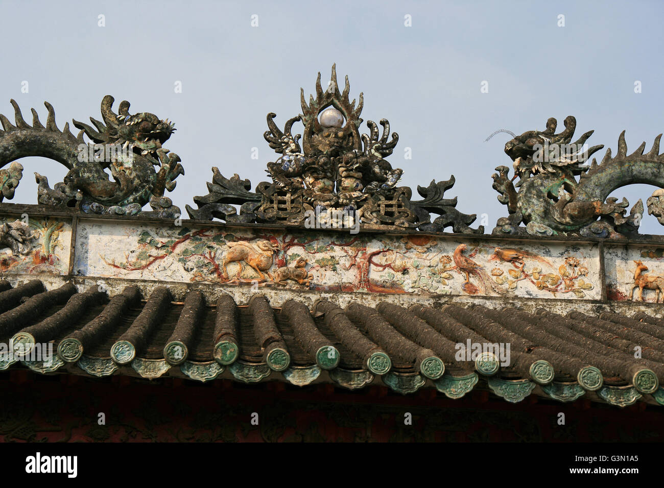 Zwei geschnitzte Drachen auf dem Dach eines chinesischen Pavillon in Hoi an (Vietnam). Stockfoto