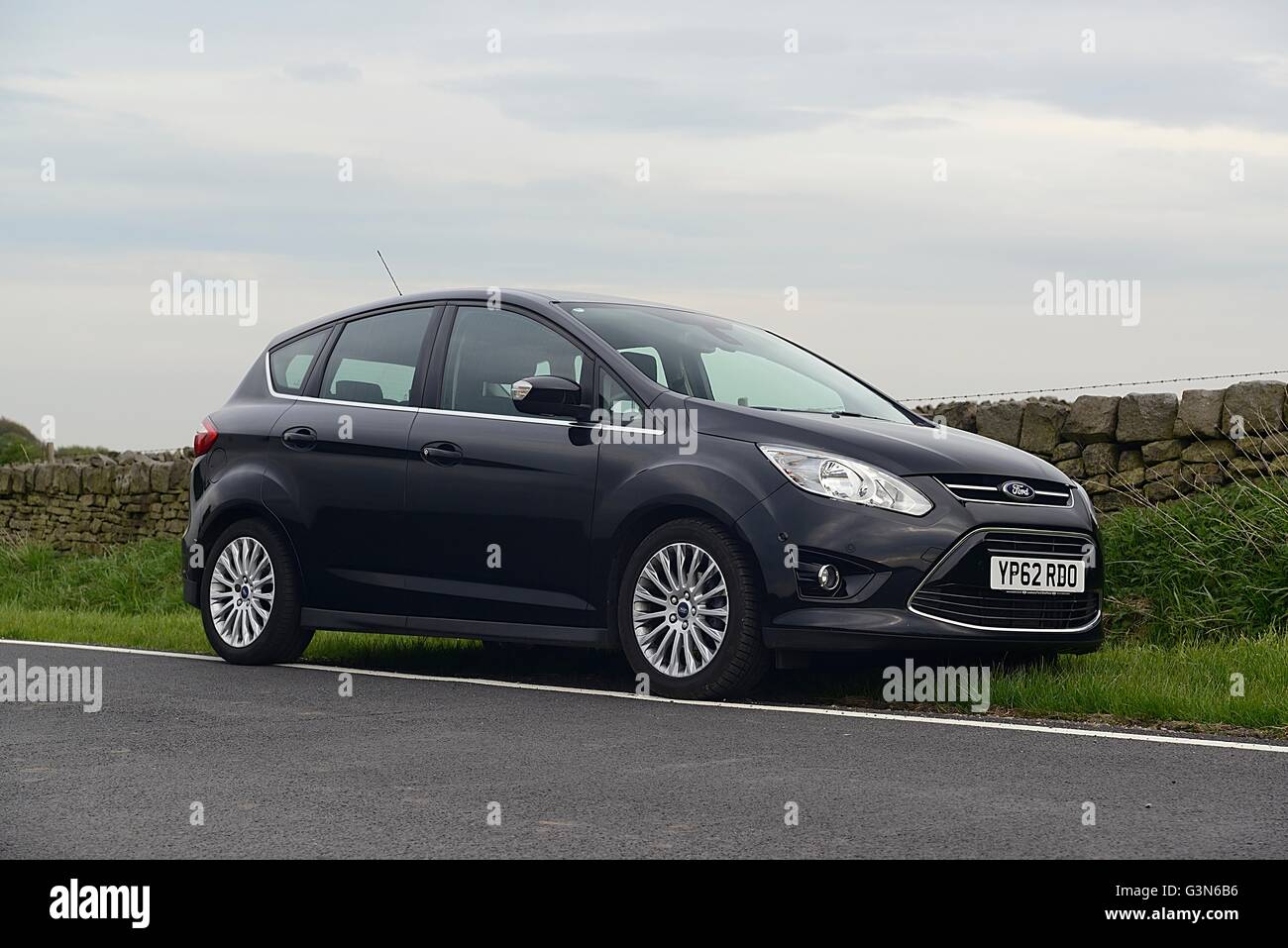 Ford CMax parkte vor einer Trockensteinmauer auf einer Landstraße von Yorkshire Stockfoto