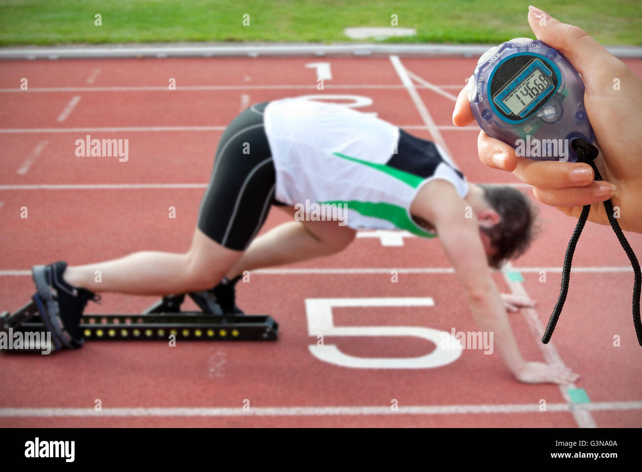 Zusammengesetztes Bild von einer Hand hält einen Timer gegen sportlicher Mann auf der Startlinie Stockfoto