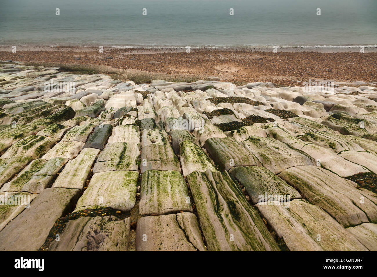 Meer-Verteidigung legte Steinen am Strand abgenutzt durch die Einwirkung von Wasser Stockfoto