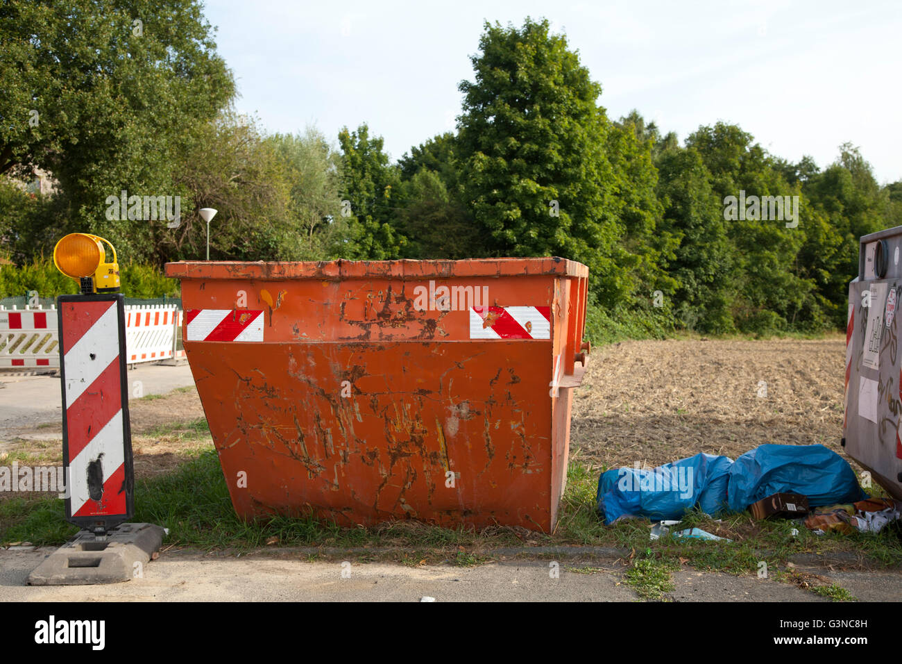 Ein Container und Müll auf der Seite einer Straße, Kamen, Ruhrgebiet, Nordrhein-Westfalen, PublicGround Stockfoto