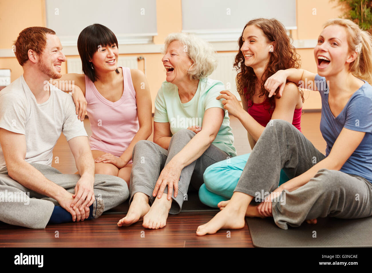 Ältere Frau voller Vitalität und Gruppe fröhlich lachend im Fitness-center Stockfoto