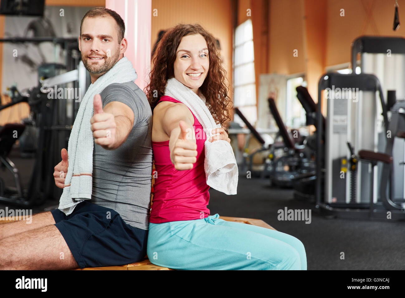 Erfolgreiche paar im Fitness-Center, die Daumen hochhalten Stockfoto