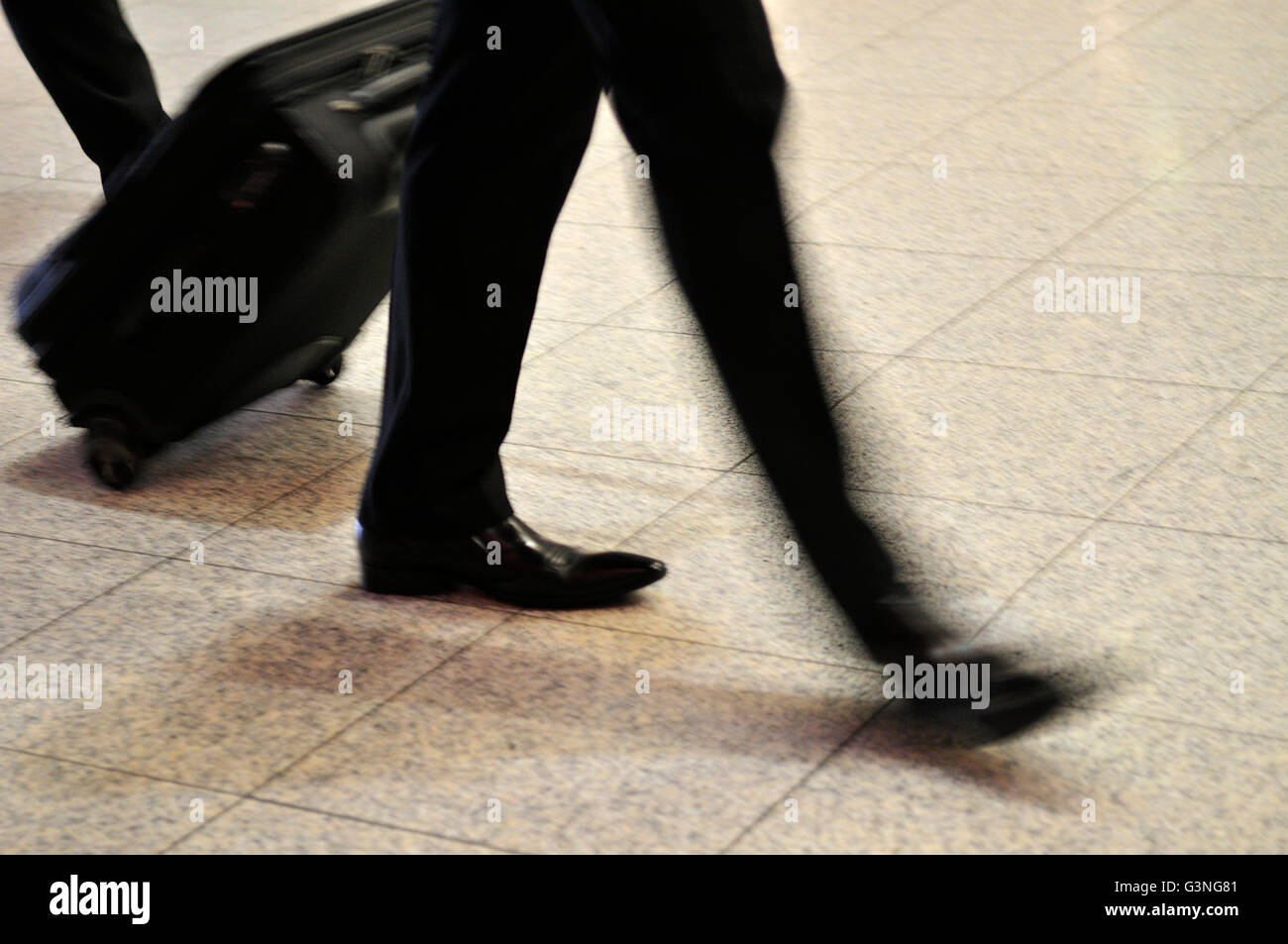 Zusammenfassung der Mann zu Fuß ziehen Rädern Koffer mit Bewegungsunschärfe Stockfoto