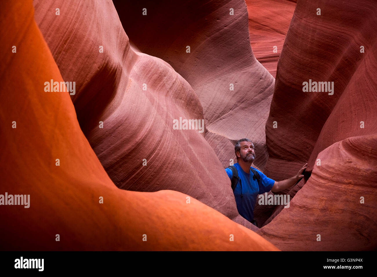 Man erforscht eine lebendige rote farbige Slotcanyon am Lower Antelope Canyon, Page, AZ, USA Stockfoto