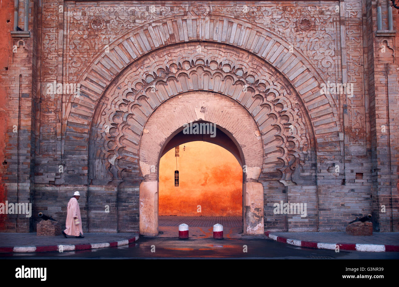 Marokkanischen Mann in weißem Kleid und Hut geht in Richtung der Bogen in eine Mauer, die zum Eingang der Saddien Gräber, Marrakesch Stockfoto