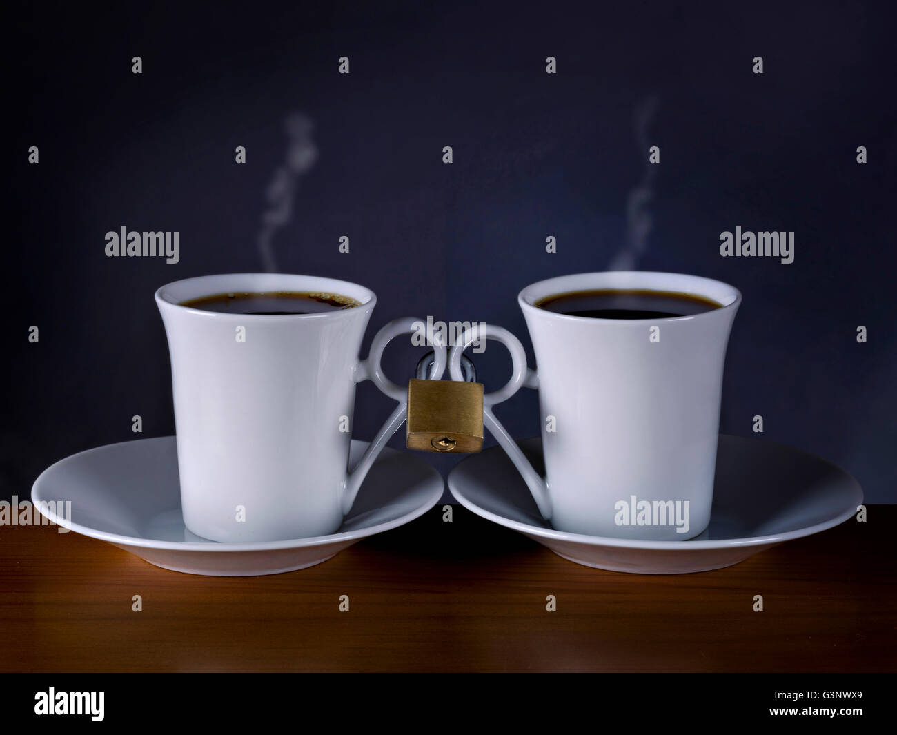 Zwei Tassen Kaffee, zusammen mit einer Sperre auf schwarzem Hintergrund Stockfoto