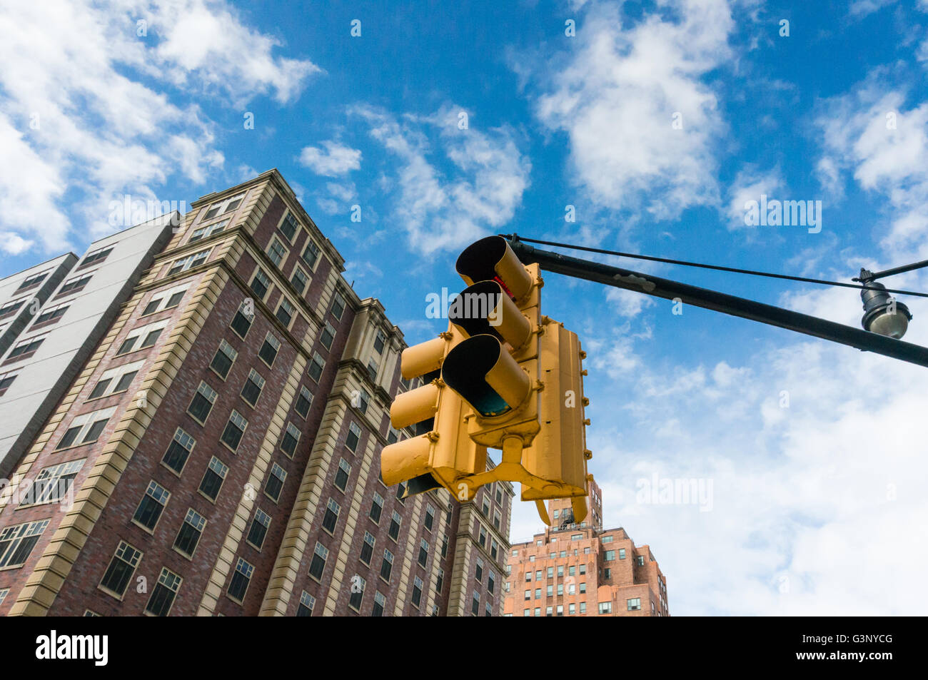 Nach oben auf eine hängende Ampel in New York mit Wohnungen im Hintergrund Stockfoto