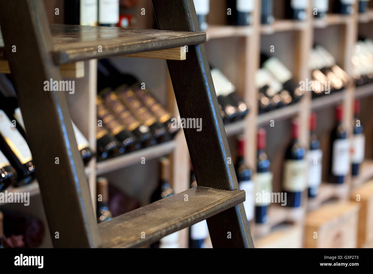 Flaschen und Hocker in einer Weinhandlung Stockfoto