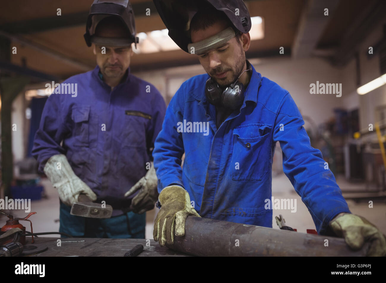 Männer arbeiten gemeinsam an einem Metallarbeiten Stockfoto