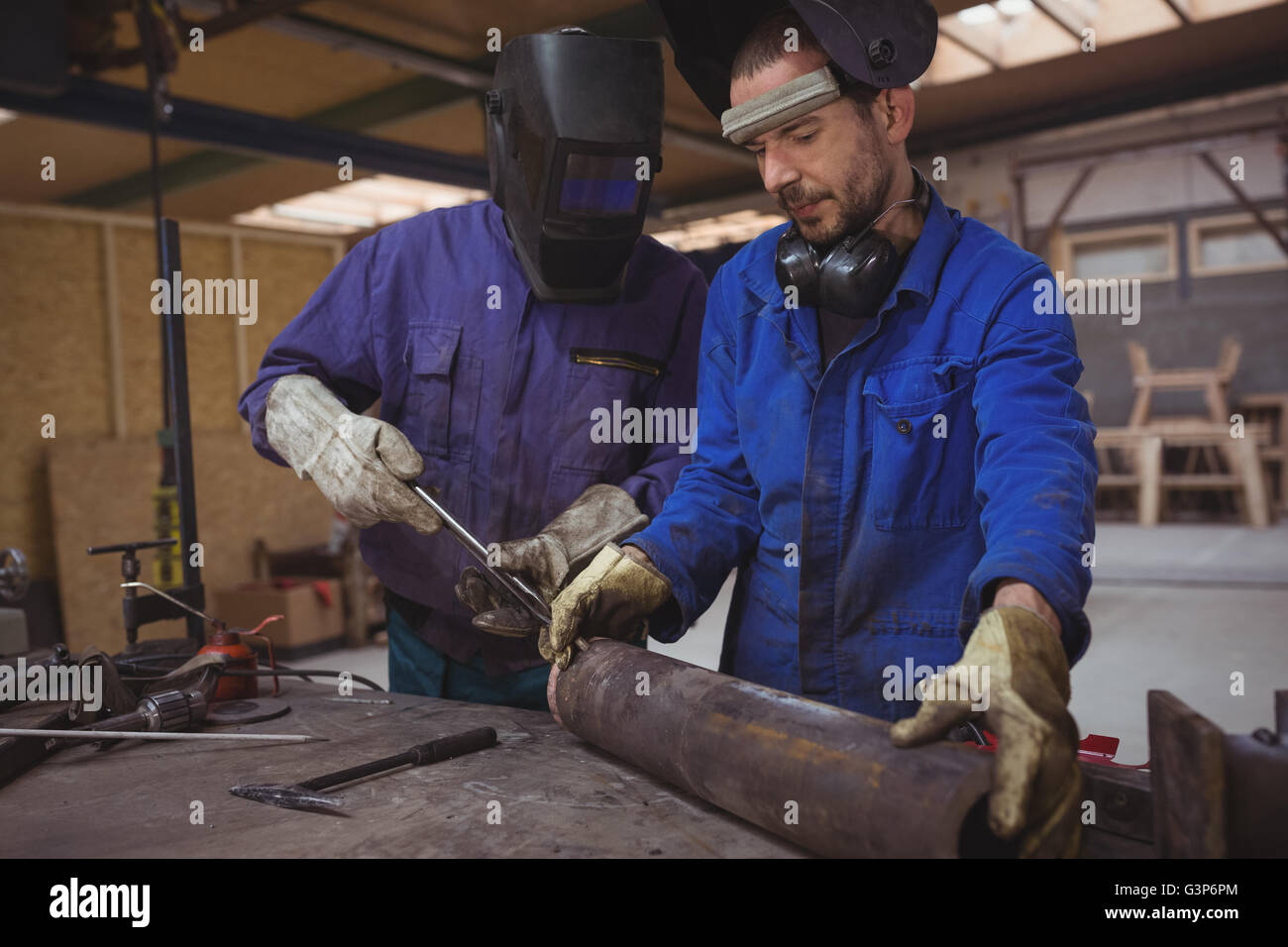 Männer arbeiten gemeinsam an einem Metallarbeiten Stockfoto