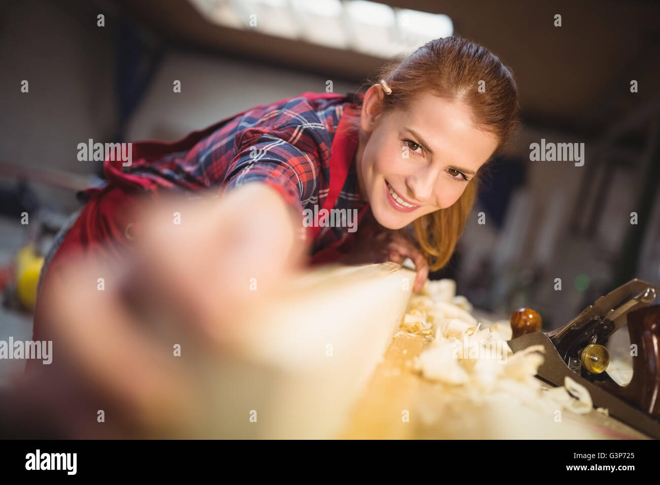 Frau Zimmermann Messlänge von Holzbrett Stockfoto