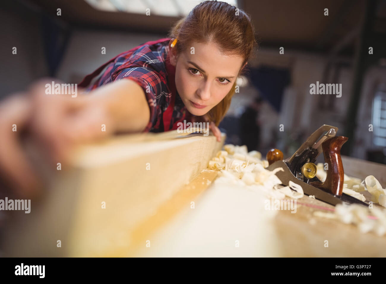 Frau Zimmermann Messlänge von Holzbrett Stockfoto