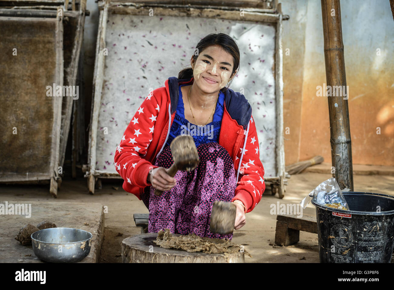 Junge Frau bereitet Substanz für die Herstellung der traditionellen Regenschirm Stockfoto