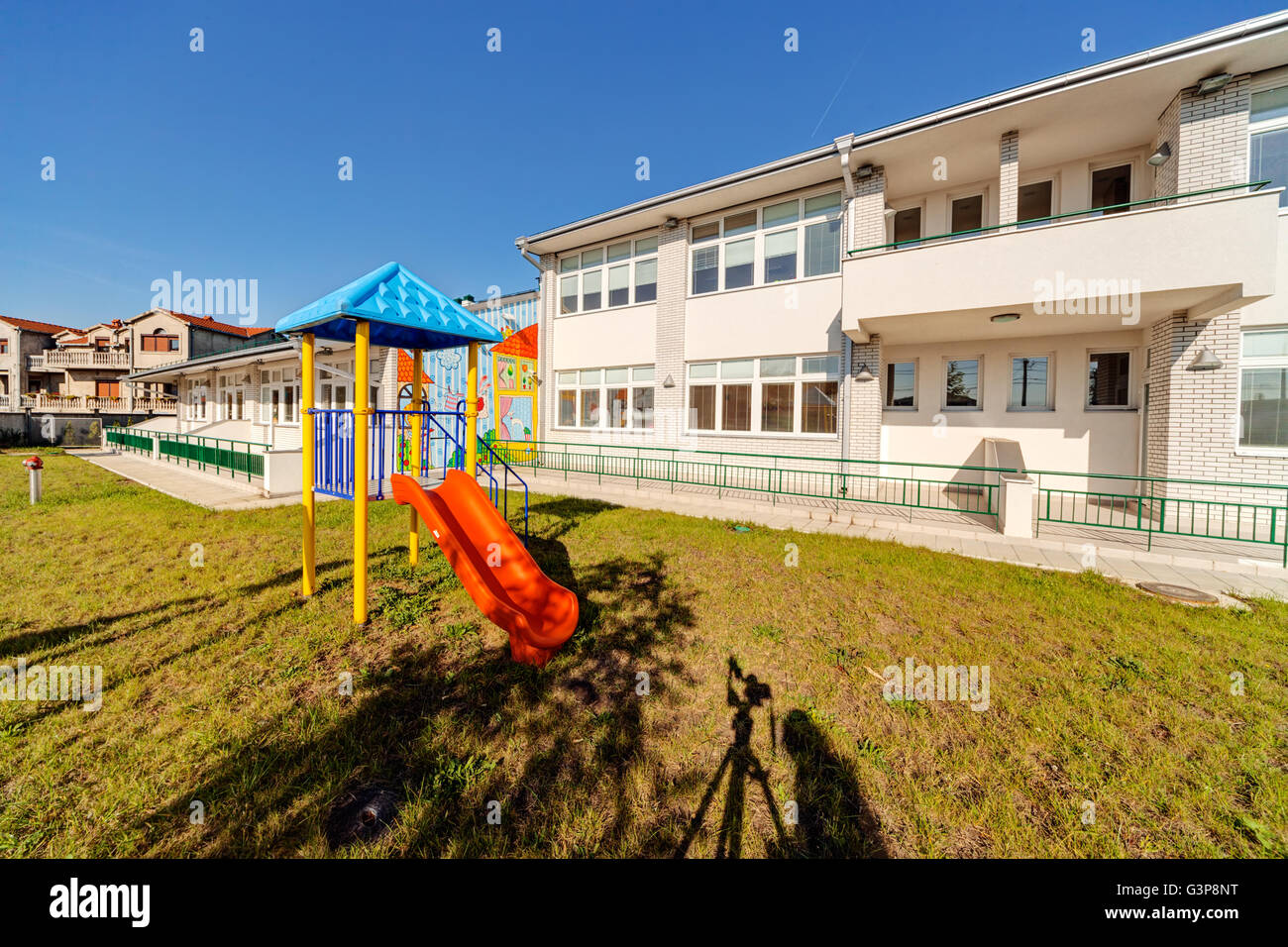 Vorschule Gebäudehülle mit Spielplatz an einem sonnigen Tag Stockfoto