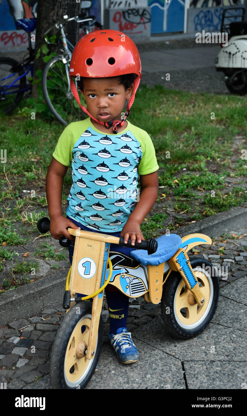 Bisschen schüchtern deutsch - afrikanischen jungen mit hölzernen Bike Fahrrad Berlin Deutschland Stockfoto