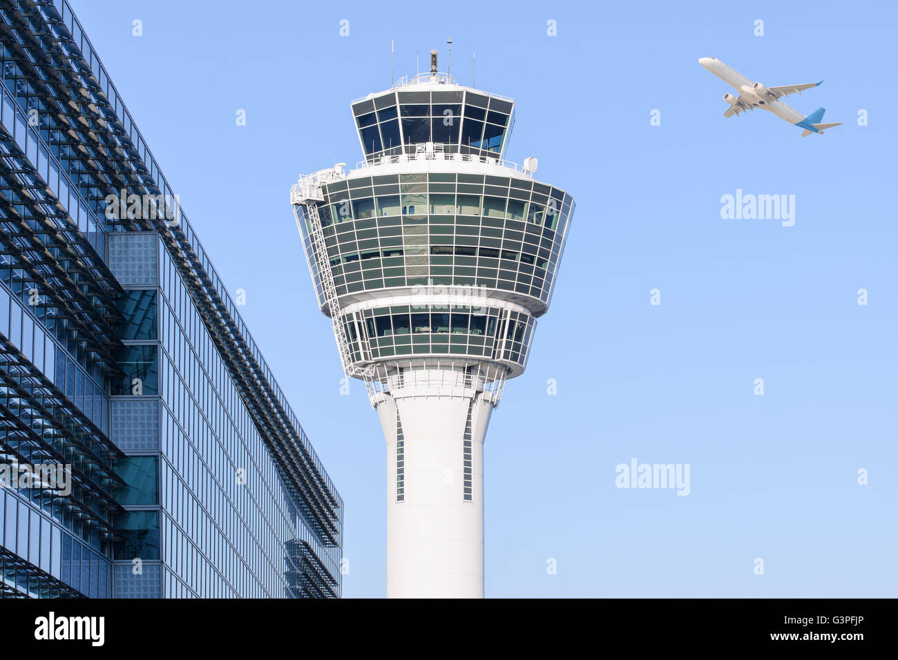 München Flughafen Kontrollturm und Terminal moderne Gebäude mit abfliegenden Flugzeug abheben Stockfoto