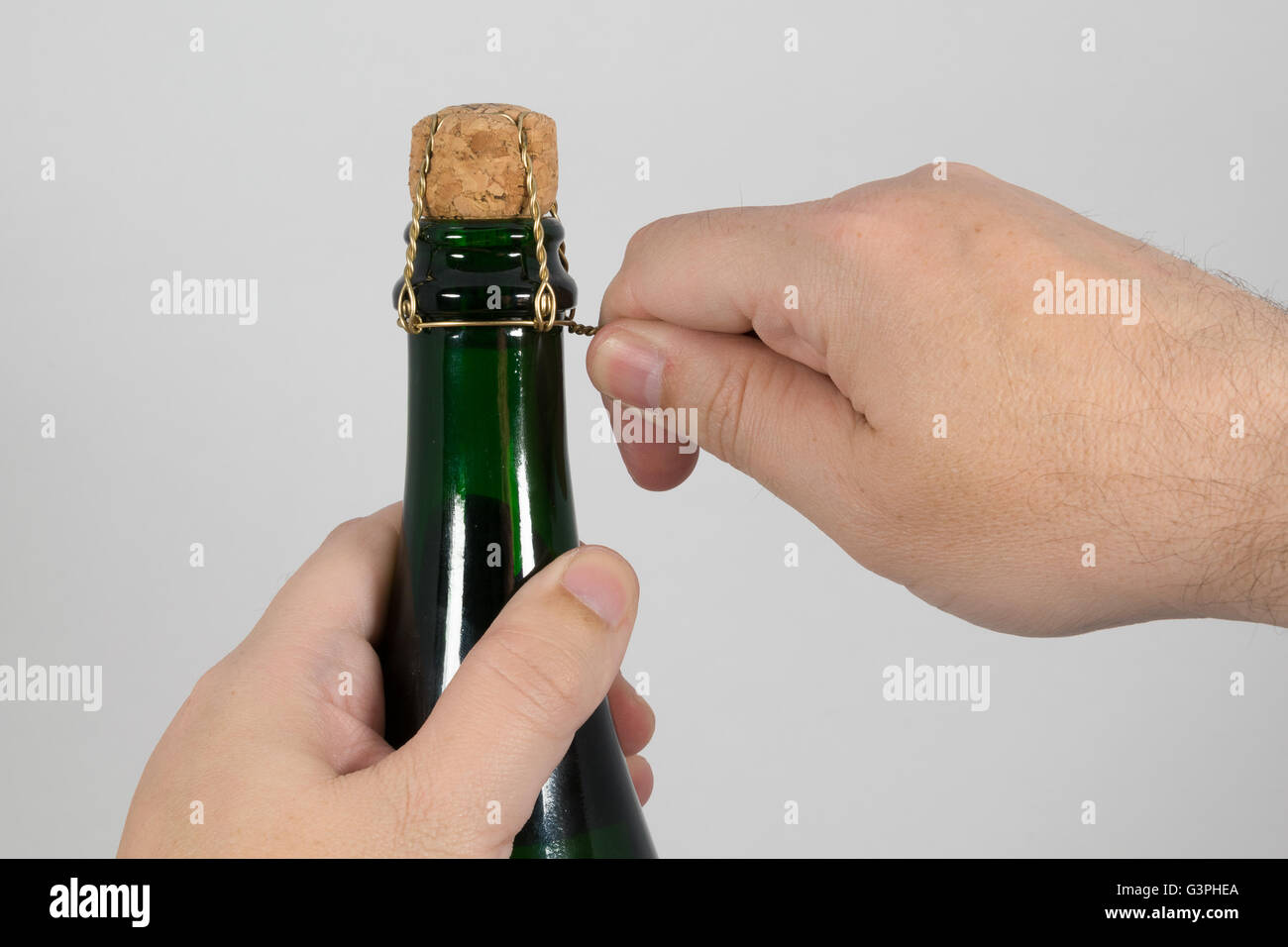 Hände den Kork-Draht auf eine Flasche abschrauben Stockfoto