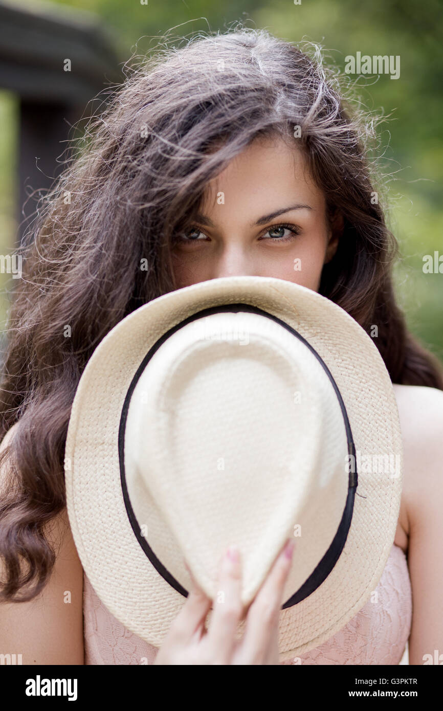Porträt einer jungen Frau, die ihr Gesicht mit Hut versteckt Stockfoto