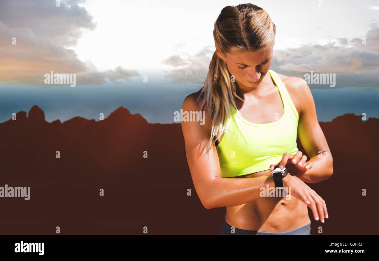 Zusammengesetztes Bild der sportliche Frau, die ihre Uhr Stockfoto