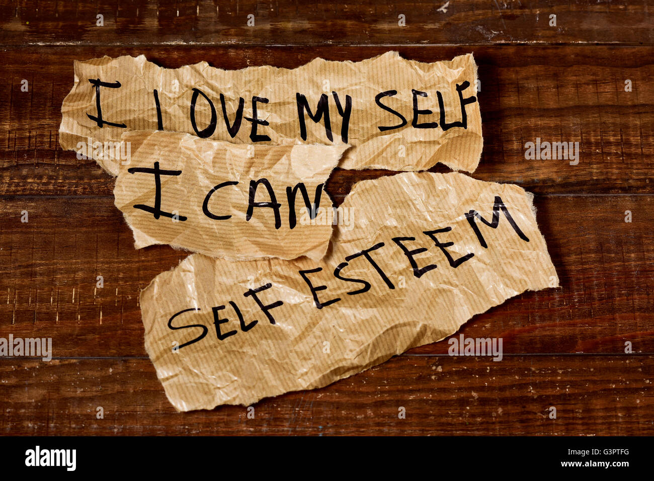 der Text ich liebe mich, ich kann und Selbstwertgefühl in einige Stücke Papier, platziert auf einer rustikalen Holzoberfläche geschrieben Stockfoto