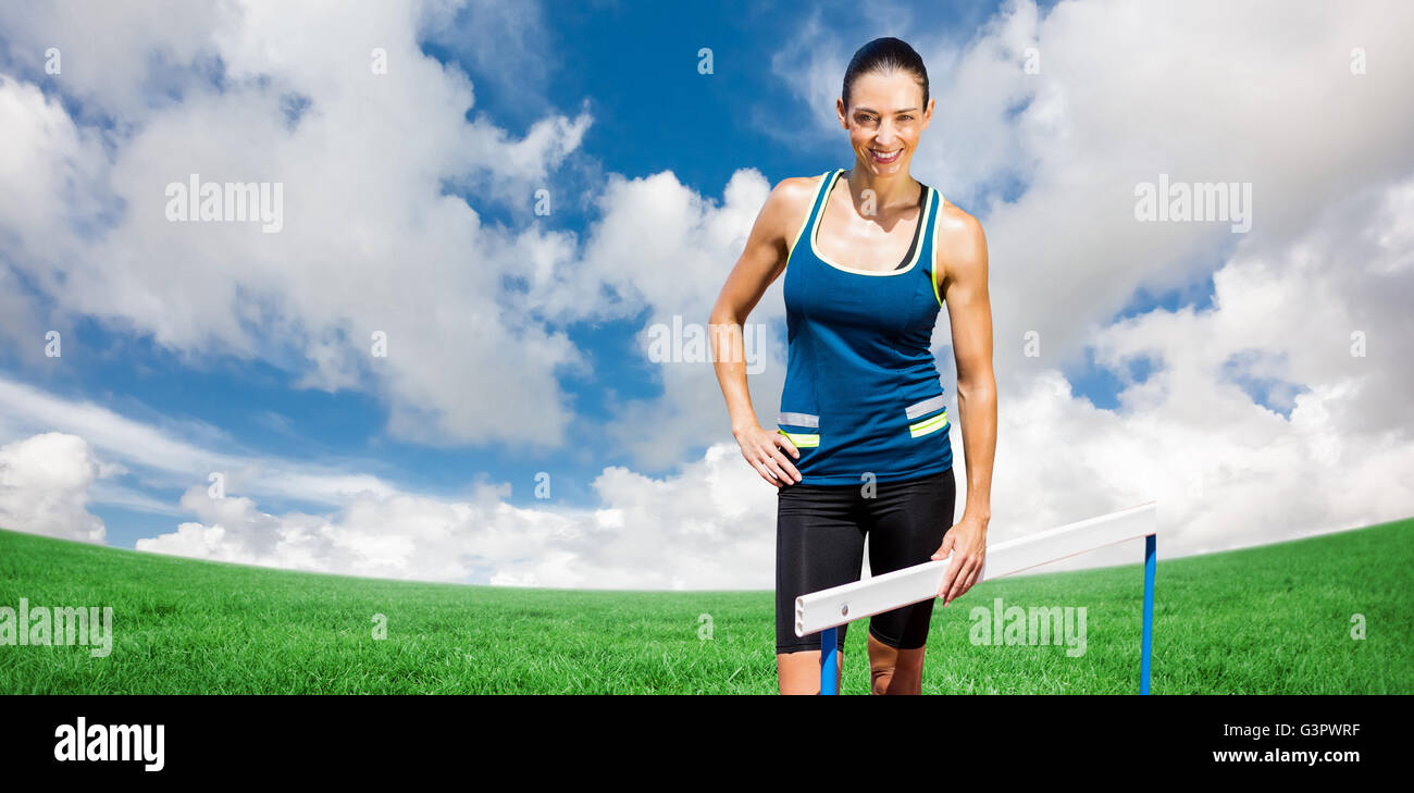 Zusammengesetztes Bild Porträt der Sportlerin posiert neben Hürde Stockfoto