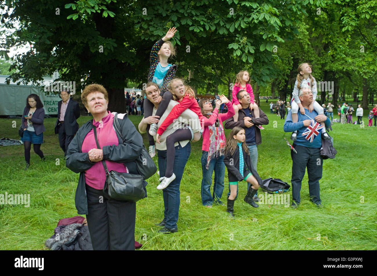 Eine Familie Gruppe von Touristen in Green Park Queens Birthday fliegen Vergangenheit beobachten. Stockfoto