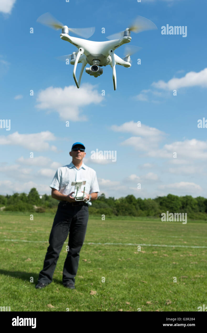 Man DJI Phantom 4 Quadrocopter Drohne im Park, England, UK Stockfoto