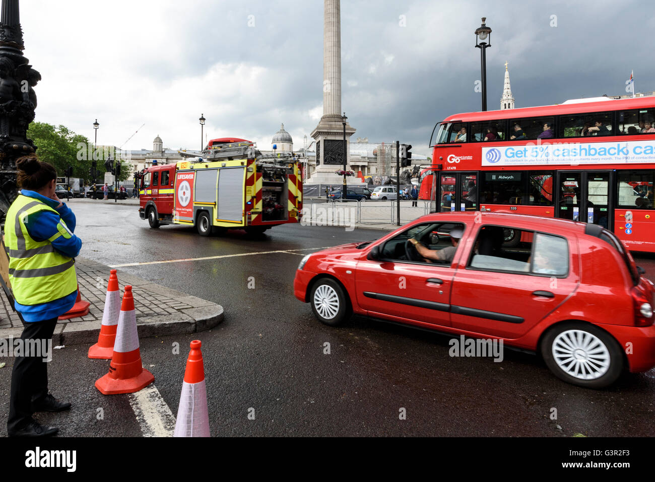 London Feuerwehrauto, roten Doppeldecker Bus und roten Auto am Trafalgar Square Kreisverkehr, UK. Stockfoto